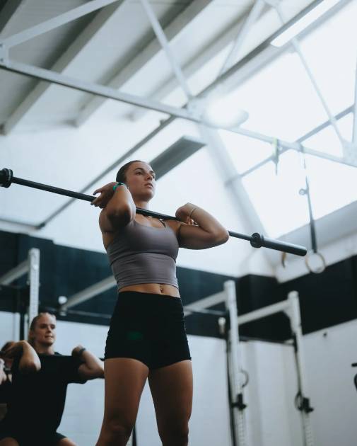 Teen lifting barbell at the training
